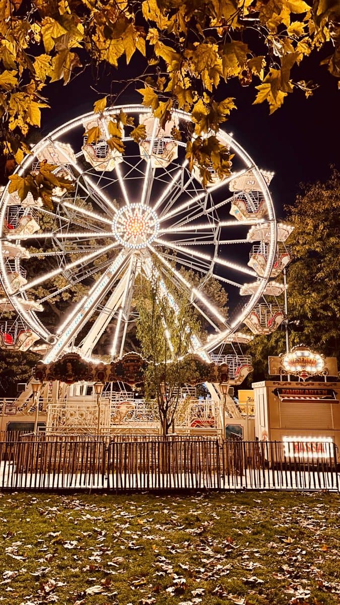Referenzen und Schaustellertradition seit 1917 Beleuchtetes Riesenrad bei einer Abendveranstaltung am Wiener Rathausplatz